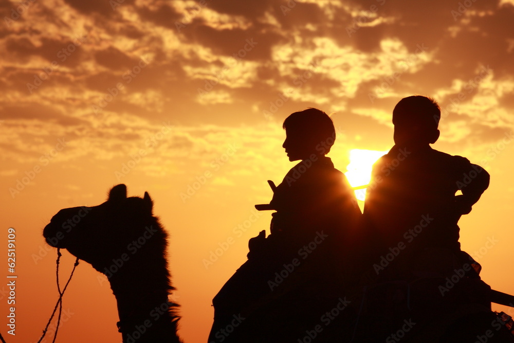 Naklejka premium Boys sit on camel