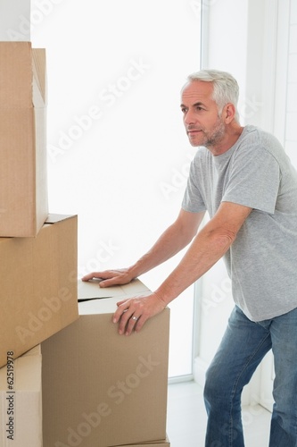 Thoughtful man looking at cardboard moving boxes © WavebreakMediaMicro