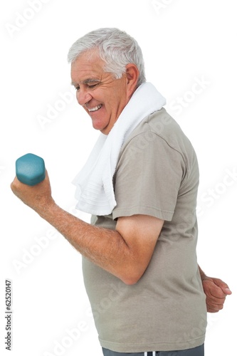 Side view of a senior man exercising with dumbbell