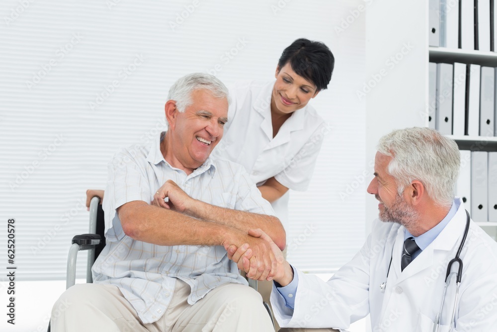 Happy senior patient and doctor shaking hands Happy senior patient and doctor shaking hands