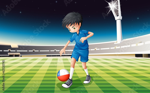 A soccer player at the field with the flag of Chile