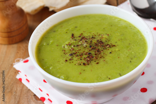 Vegan green pea soup with coconut milk and spices close-up