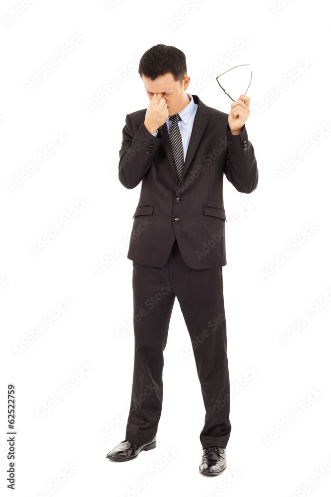 young businessman rubbing his eyes and holding glasses young businessman rubbing his eyes and holding glasses