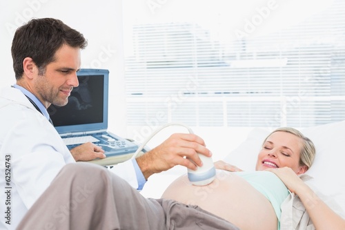 Smiling pregnant blonde woman having an ultrasound scan