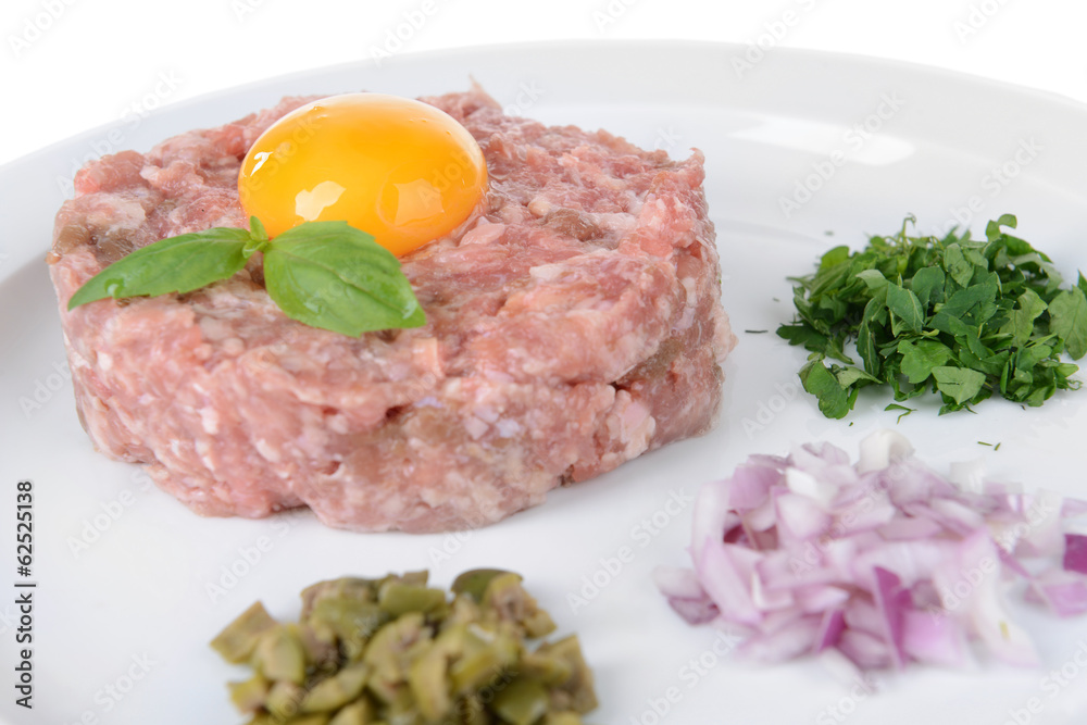 Delicious steak tartare with yolk on plate close-up