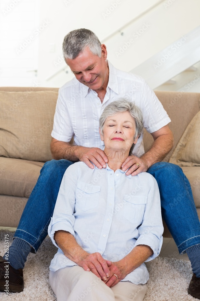 Man giving his relaxed senior wife a shoulder rub