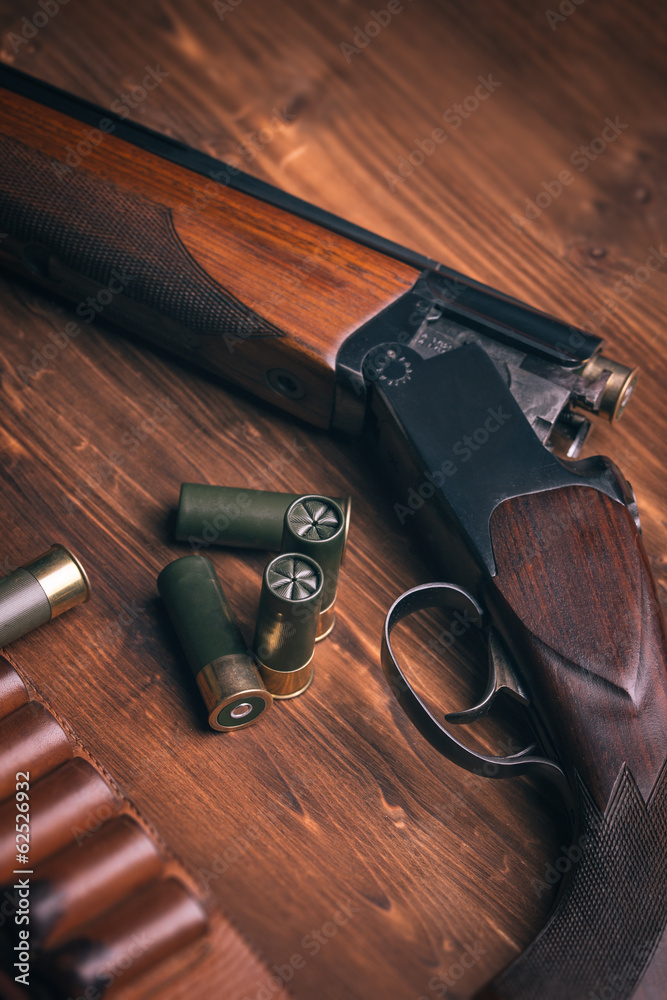 Shotgun with shells on wooden background