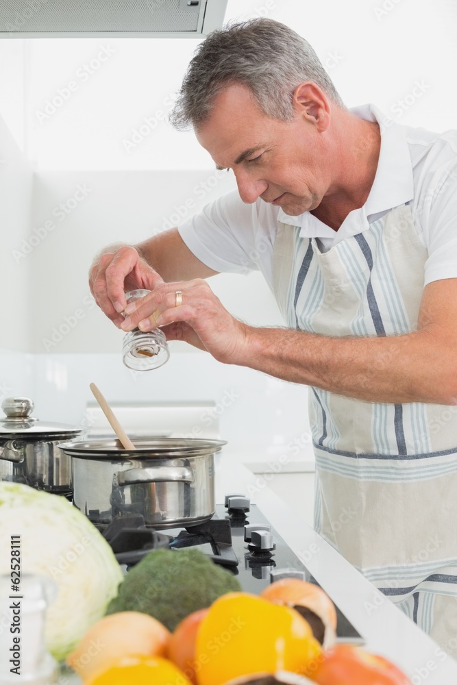 Side view of a man preparing food in kitchen
