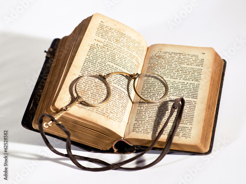 Vintage lorgnettes lying on an old book