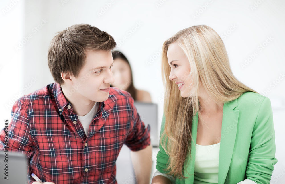 smiling students looking at each other at school smiling students looking at each other at school