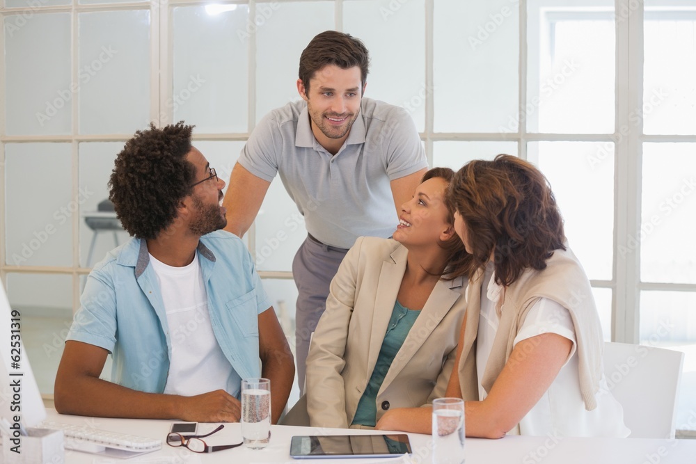 Business people having a conversation at office desk Business people having a conversation at office desk