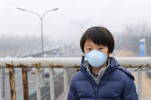 Fotografía Asian boy wearing mouth mask against air pollution (Beijing)
