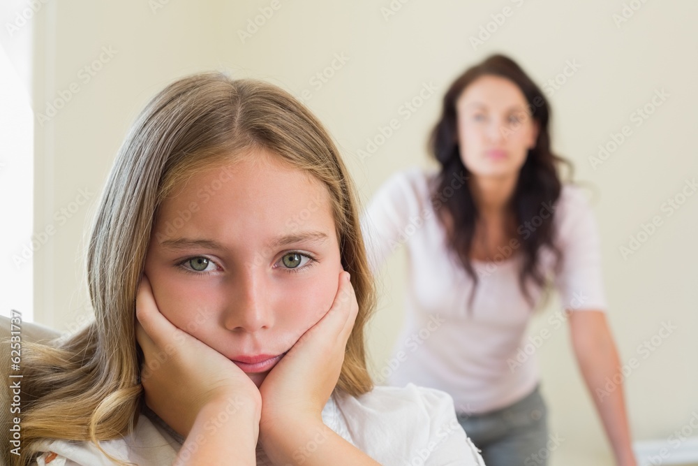 Sad girl with mother in background Sad girl with mother in background