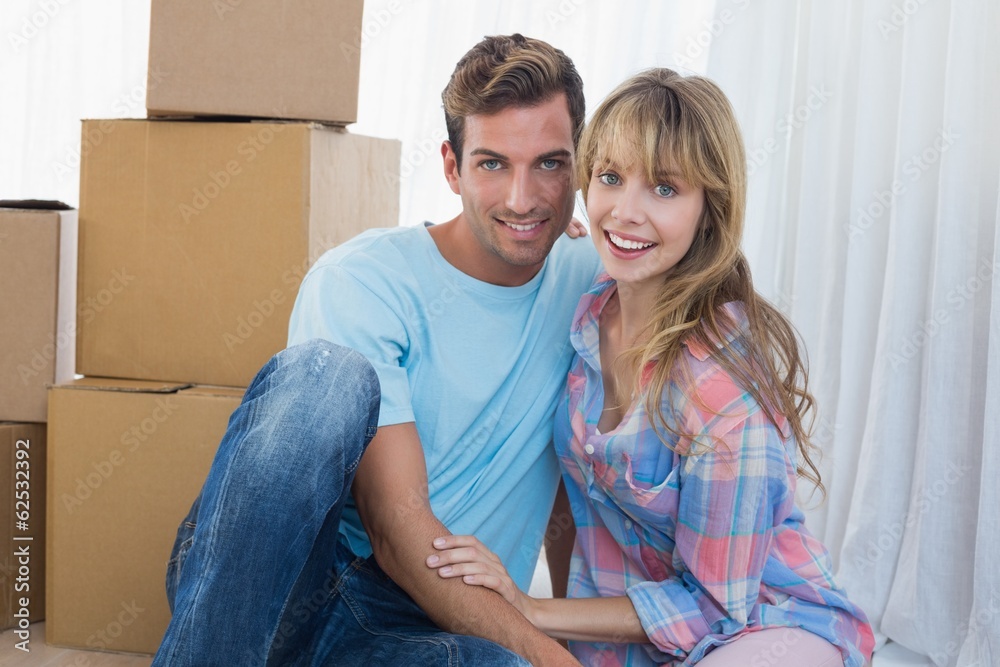 Couple sitting against cardboard boxes in new house Couple sitting against cardboard boxes in new house