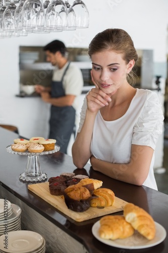 Cafe owner with sweet food at counter