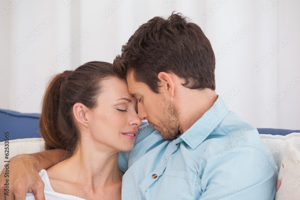 Loving couple with eyes closed on couch