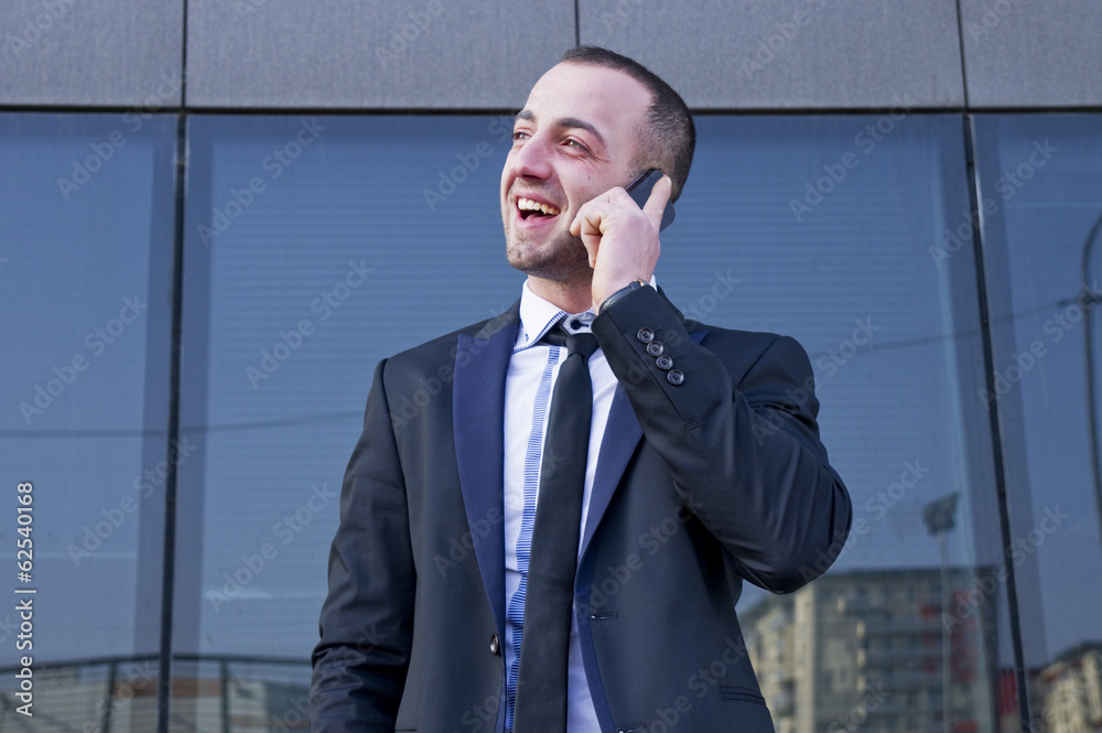 young businessman talking on the phone outdoors young businessman talking on the phone outdoors