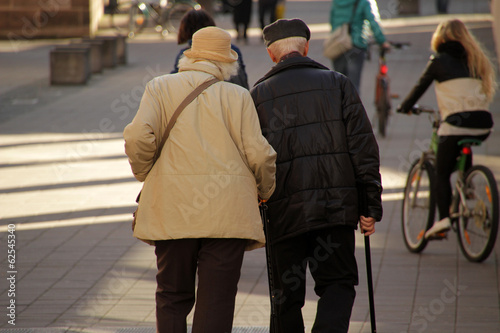 Pareja de ancianos paseando por la calle un día de invierno photo