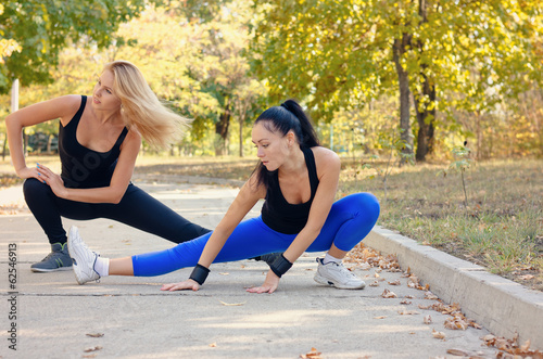 Two fit athletic woman working out in a park
