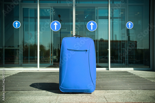 suitcase waiting for traffic in front of the closed doors