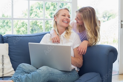 Mother and daughter with laptop looking at each other © lightwavemedia
