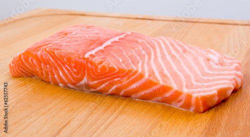 Uncooked salmon fillet on a wooden board