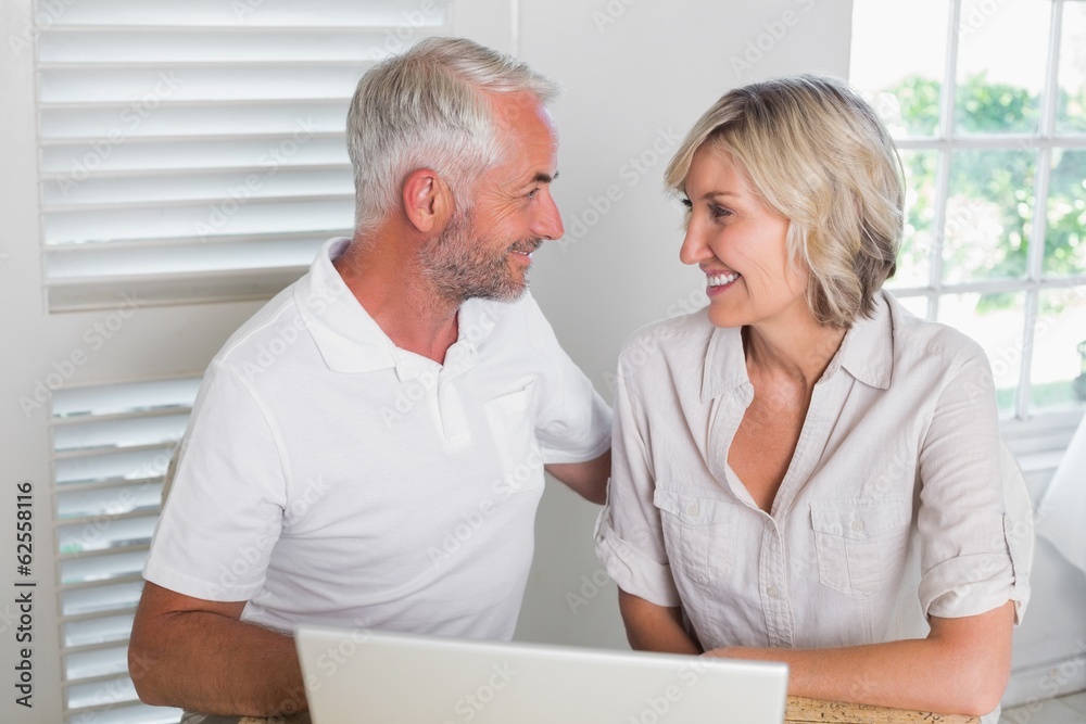 Smiling mature couple using laptop Smiling mature couple using laptop