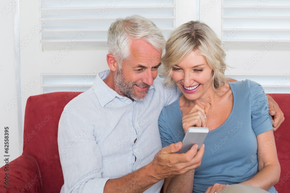 Smiling mature couple reading text message Smiling mature couple reading text message