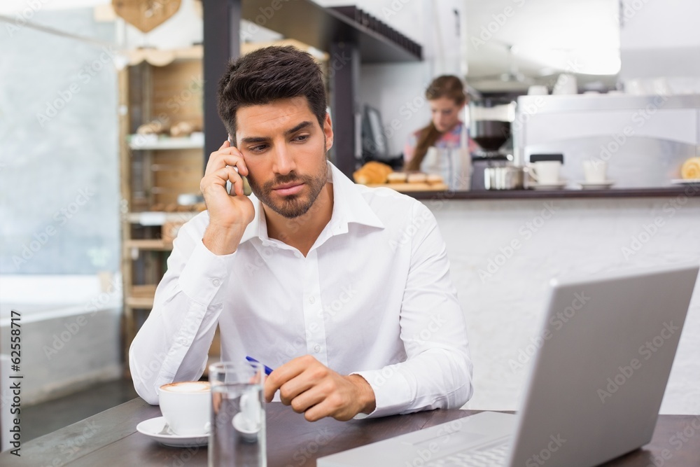 Fototapeta premium Man using mobile phone in coffee shop
