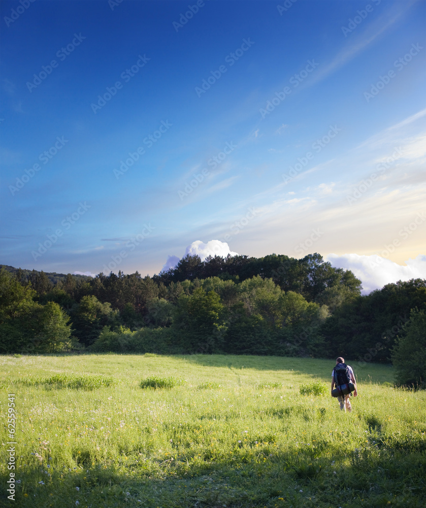 tourist walking on a footpath across the field