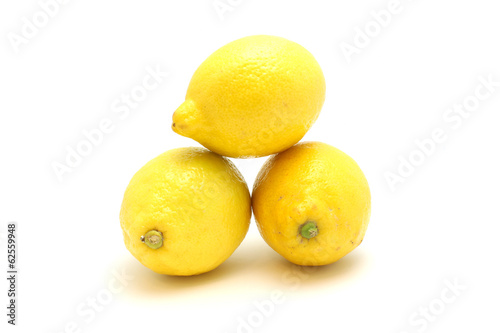 Bright lemons on a white background lie on each other