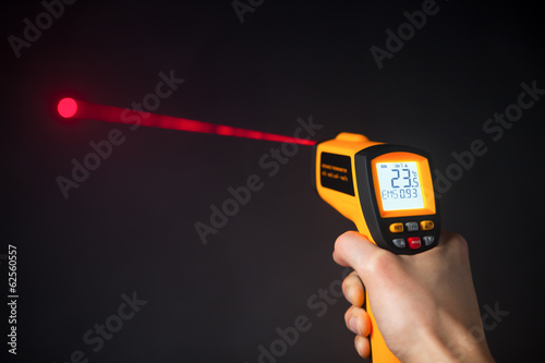 infrared laser thermometer in hand photo