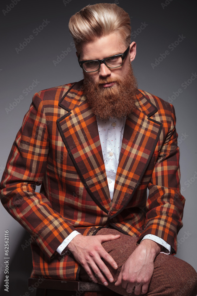 Fototapeta premium dramatic fashion model with long beard and glasses sitting