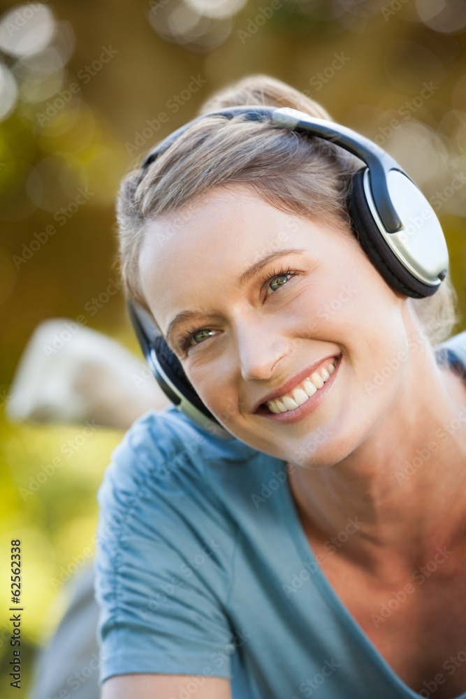 Beautiful young woman enjoying music in park Beautiful young woman enjoying music in park