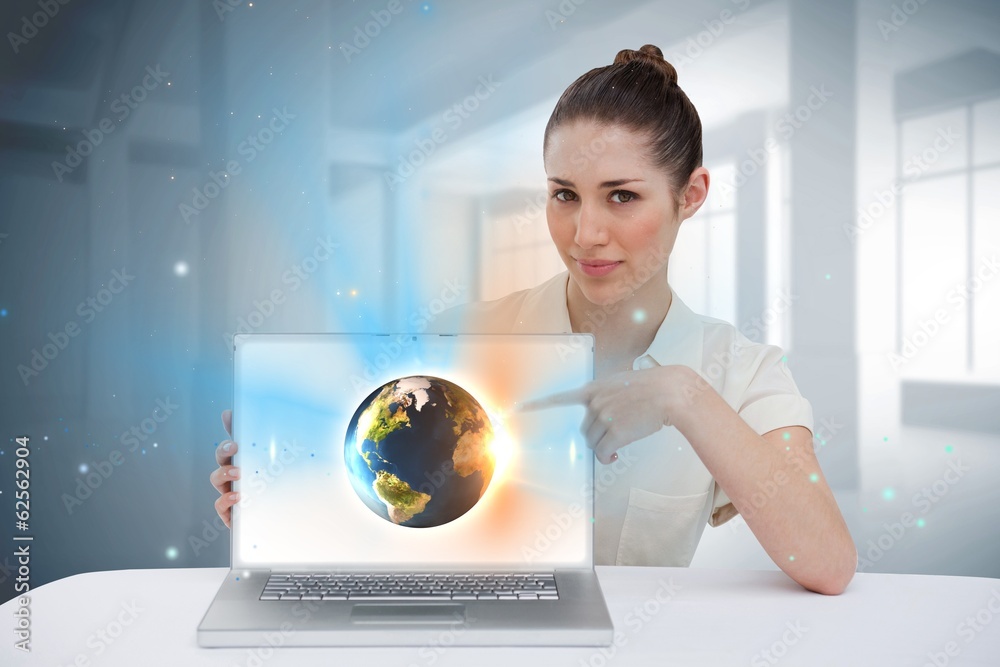 Businesswoman pointing to her laptop showing earth graphic Businesswoman pointing to her laptop showing earth graphic