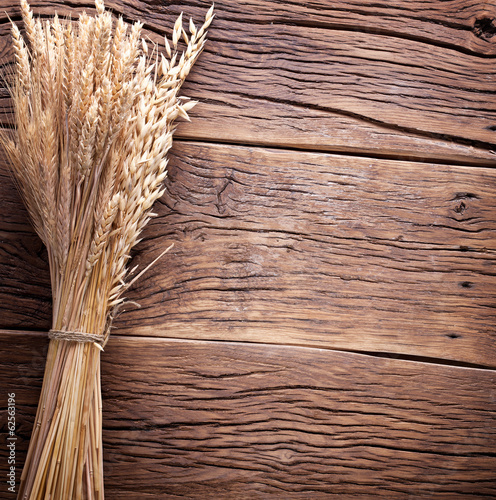 Ears of wheat on old wooden table.