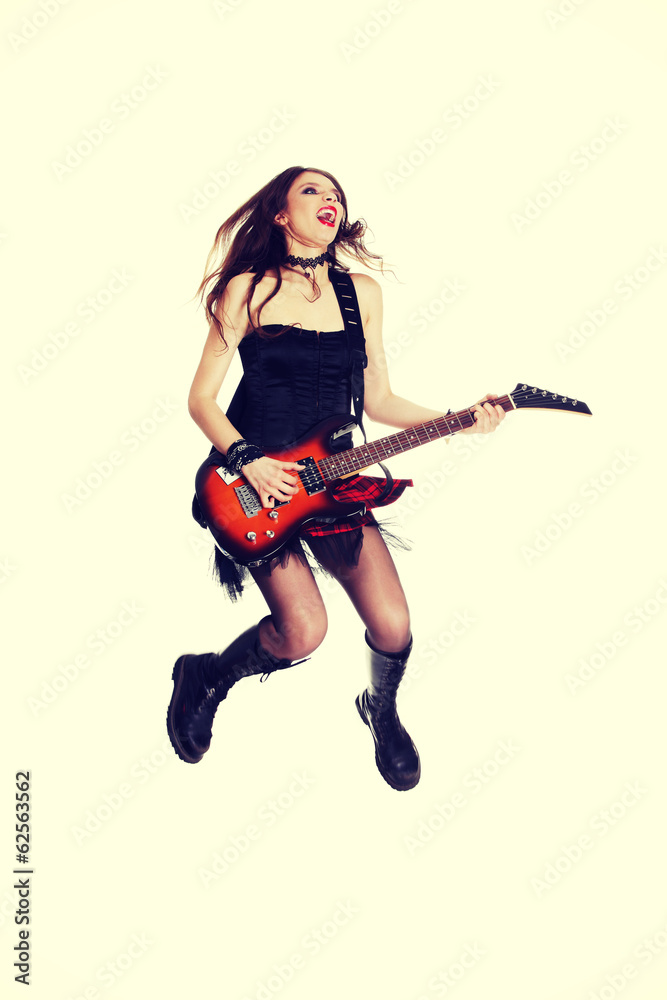 Girl with electric guitar is playing and jumping. Girl with electric guitar is playing and jumping.