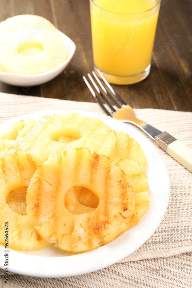 Juicy grilled pineapple on plate on table close-up Juicy grilled pineapple on plate on table close-up