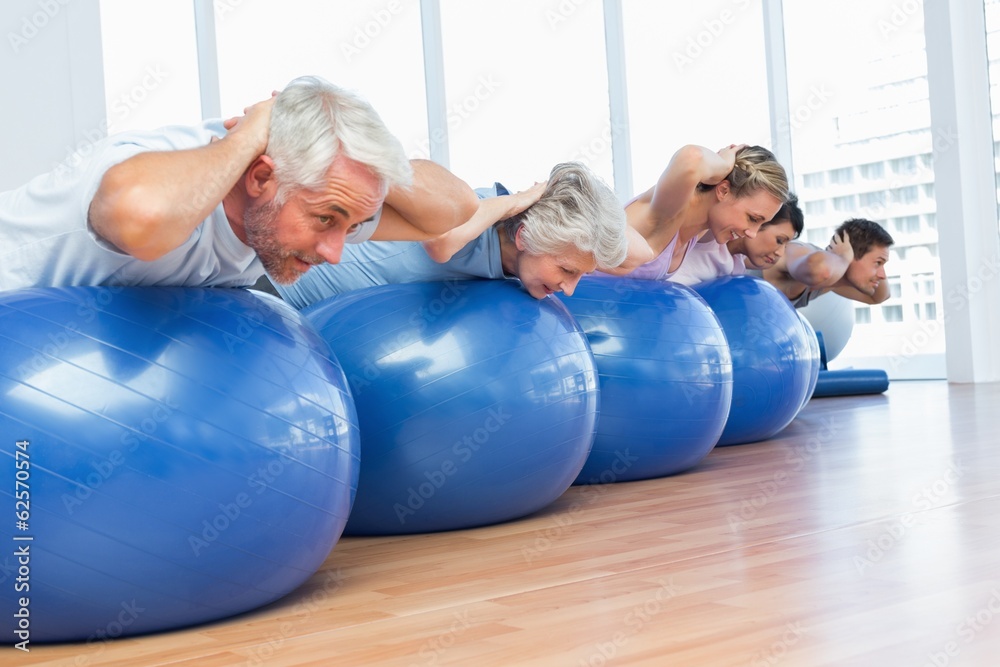 People stretching on exercise balls in gym