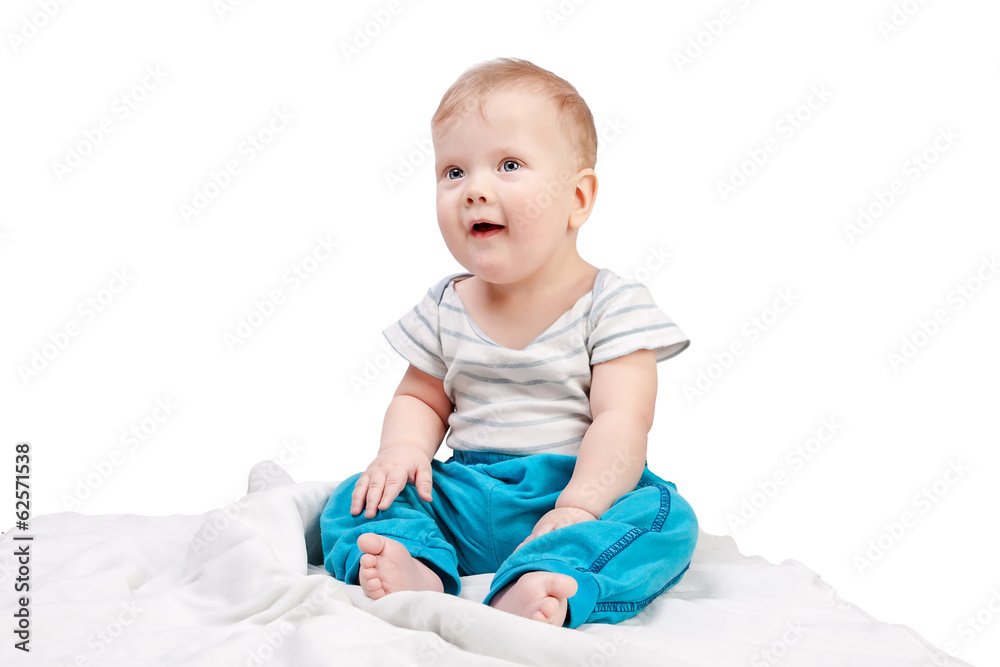 Cute baby boy sitting on a white blanket isolated on white Cute baby boy sitting on a white blanket isolated on white
