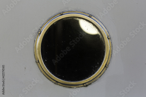 Metal porthole on white boat