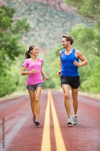 Two people jogging for fitness running on road