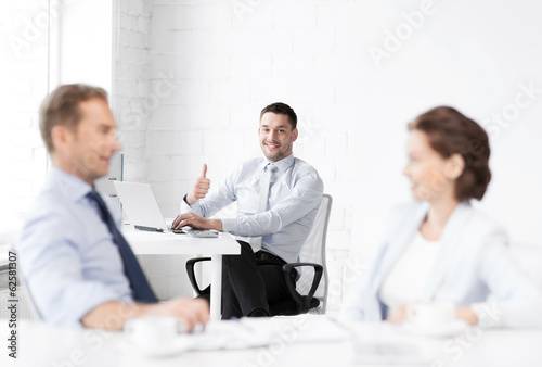 happy businessman showing thumbs up in office