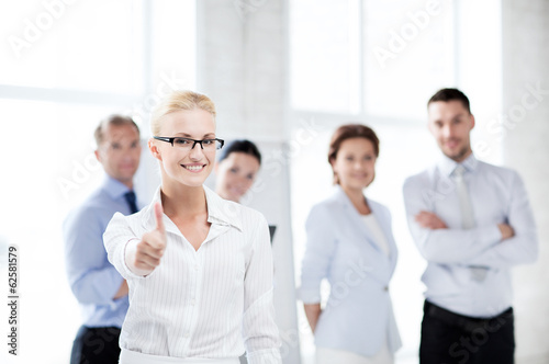 businesswoman in office showign thumbs up