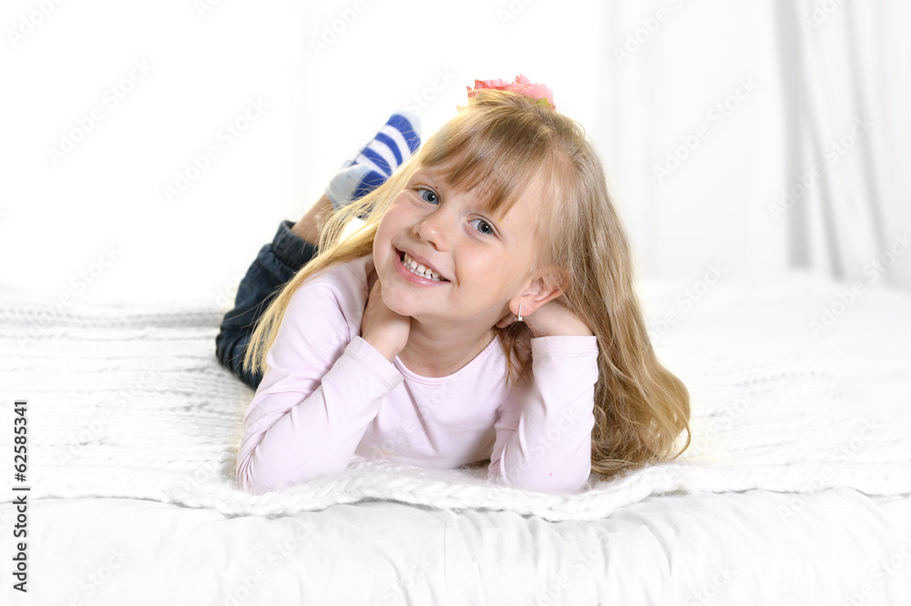 sweet little blonde girl lying happy on bed sweet little blonde girl lying happy on bed