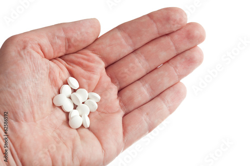 pills on hand close-up isolated on white