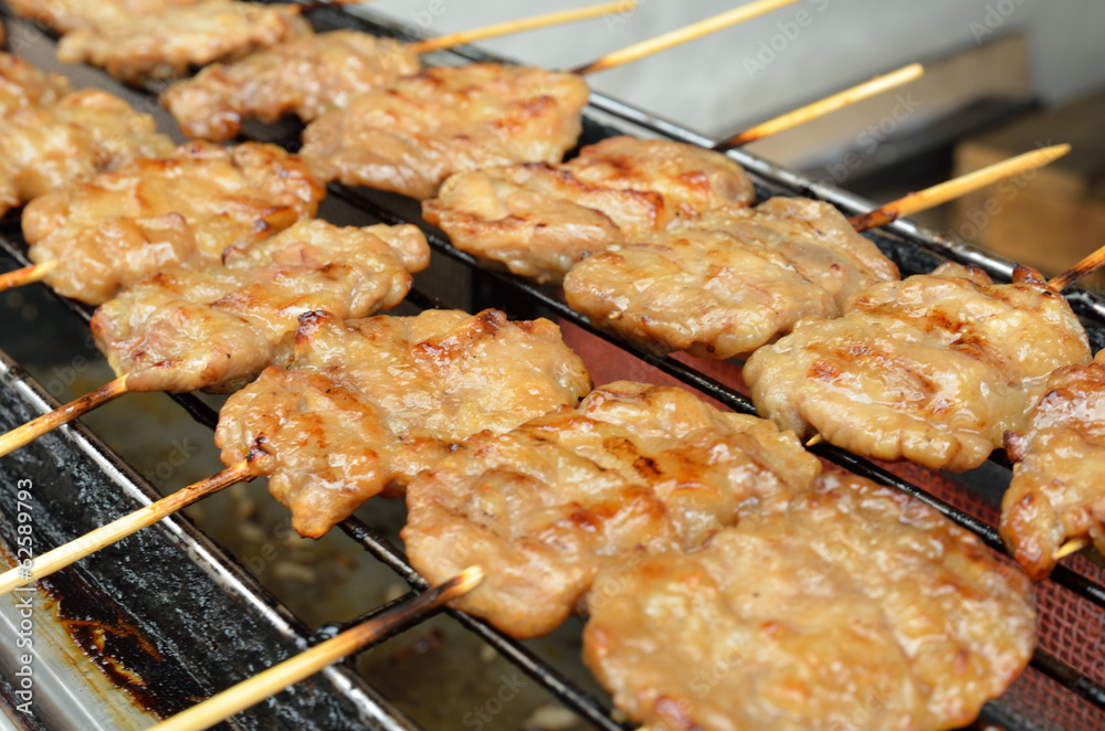 Pork skewers are cooked on a gas stove