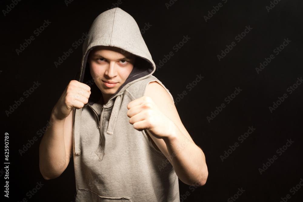 Determined angry young boxer in a hooded top Determined angry young boxer in a hooded top