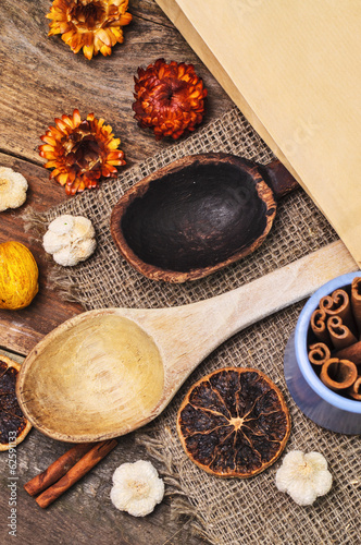 An old wooden spoon and a new one with dried fruits and spices a