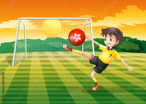 A female athlete kicking the ball with the flag of Hong Kong